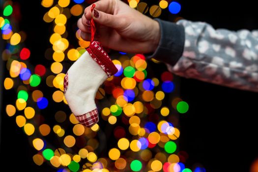 Woman's hands hold christmas decoration. Christmas and New Year holidays background, winter season with Christmas ornaments and blurred lights