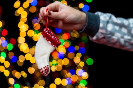 Woman's hands hold christmas decoration. Christmas and New Year holidays background, winter season with Christmas ornaments and blurred lights