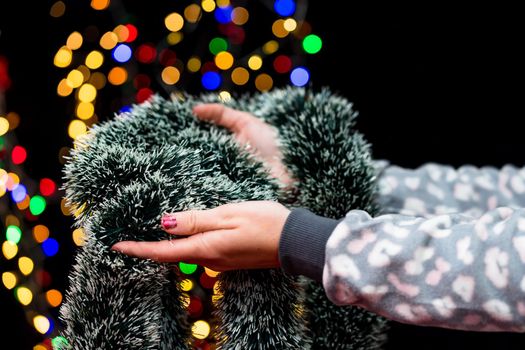 Woman's hands hold christmas decoration. Christmas and New Year holidays background, winter season with Christmas ornaments and blurred lights