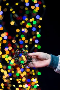 Woman's hands hold christmas decoration. Christmas and New Year holidays background, winter season with Christmas ornaments and blurred lights