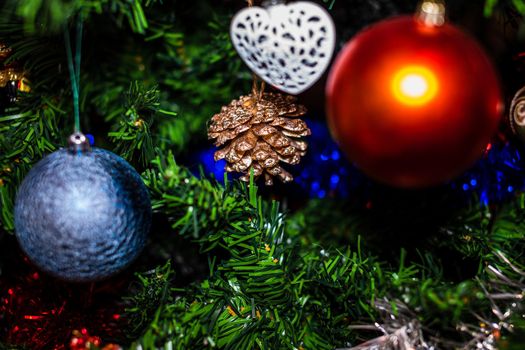 Christmas hanging decorations on fir tree. Decorated Christmas tree. Fir branch with Christmas baubles decorations.