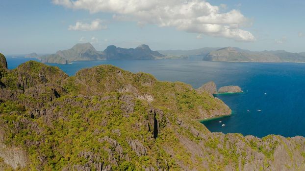 Cove with lagoons and the tropical islands, aerial view. Seascape with tropical rocky islands, ocean blue water. islands and mountains covered with tropical forest. El nido, Philippines, Palawan. Tropical Mountain Range
