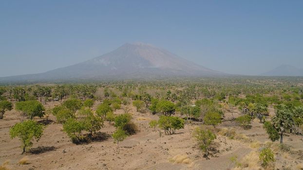 Aerial view volcano mount Agung Bali, Indonesia. tropical landscape savanna with low trees at foot volcano. Rural mountain landscape.