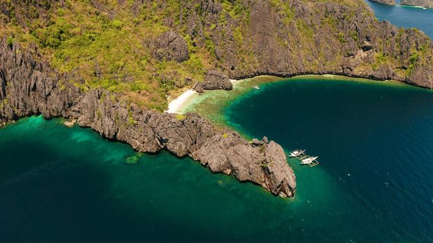 Aerial drone tropical landscape bay with beach and clear blue water surrounded by cliffs. El nido, Philippines, Palawan. Seascape with tropical rocky islands, ocean blue water. Summer and travel vacation concept