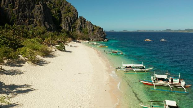aerial drone tropical island and sand beach with palm trees. Malajon Island, Philippines, Palawan. tourist boats on coast tropical island. Summer and travel vacation concept. beach and blue clear sea water