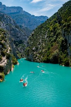 cliffy rocks of Verdon Gorge at lake of Sainte Croix, Provence, France, Provence Alpes Cote d Azur, blue green lake with boats in France Provence. Europe June 2020