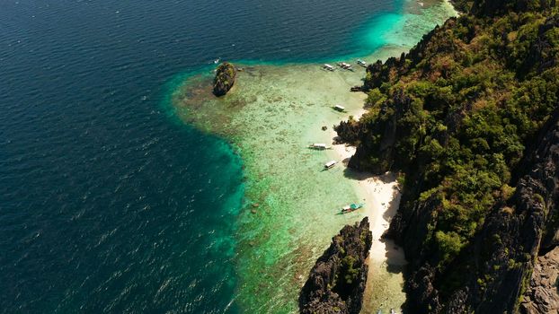Aerial drone tropical landscape bay with beach and clear blue water surrounded by cliffs. El nido, Philippines, Palawan. Seascape with tropical rocky islands, ocean blue water. Summer and travel vacation concept