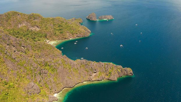 aerial view of bay and the tropical islands. Seascape with tropical rocky islands, ocean blue water. islands and mountains covered with tropical forest. El nido, Philippines, Palawan. Tropical Mountain Range