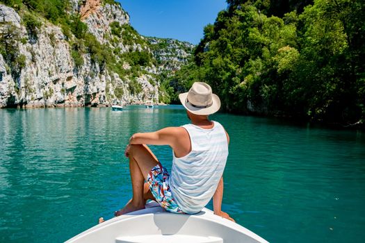 cliffy rocks of Verdon Gorge at lake of Sainte Croix, Provence, France, Provence Alpes Cote d Azur, blue green lake with boats in France Provence. Europe, young men in paddle boat