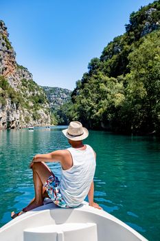 cliffy rocks of Verdon Gorge at lake of Sainte Croix, Provence, France, Provence Alpes Cote d Azur, blue green lake with boats in France Provence. Europe, young men in paddle boat