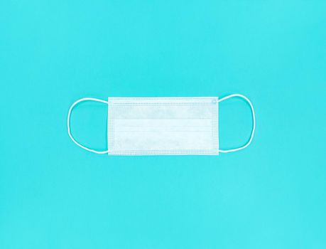 Medical disposable face mask on a blue background.