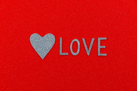 Saint Valentine's day love text and silver heart on textured red background