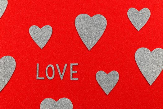 Saint Valentine's day love text and silver hearts on red background design
