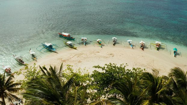 Tropical island in the ocean with palm trees on white sand beach. Guyam island, Philippines, Siargao. Summer and travel vacation concept