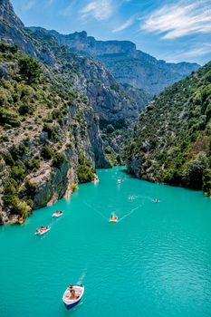 cliffy rocks of Verdon Gorge at lake of Sainte Croix, Provence, France, Provence Alpes Cote d Azur, blue green lake with boats in France Provence. Europe June 2020