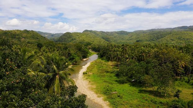Mountains and hills are covered with evergreen forest. Beautiful landscape in the Philippines. A river in the mountains on Leyte Island, Philippines.