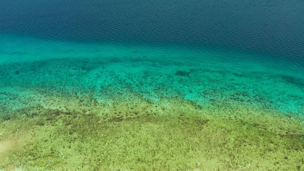 Sea water surface in lagoon and coral reef, copy space for text, aerial view.Top view transparent turquoise ocean water surface. background texture
