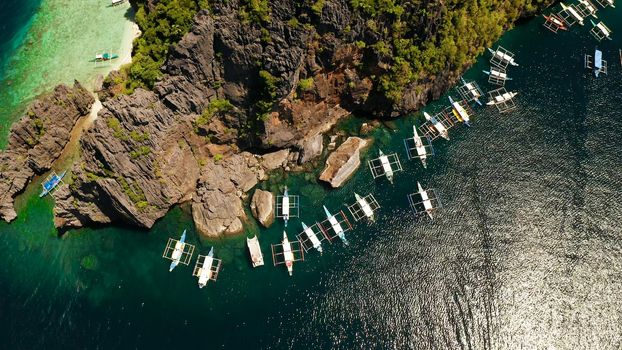 Tourist boats over tropical lagoon and coral reef. El nido, Philippines, Palawan. tropical landscape bay with beach and clear blue water surrounded by cliffs
