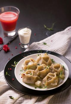 Manti or manty dumplings in a traditional bowl on wooden table