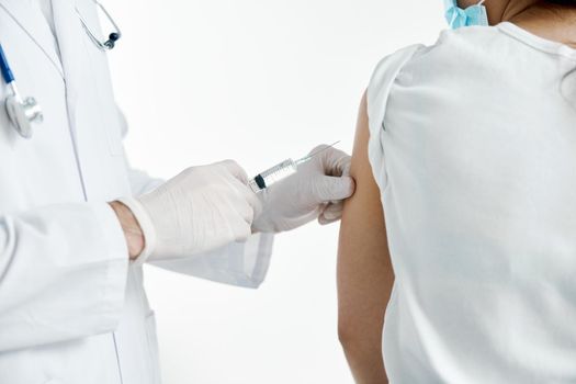 doctor with a syringe in hand injecting a vaccine in protective gloves in a hospital. High quality photo