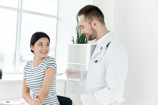 male doctor next to the patient giving an injection in the shoulder. High quality photo