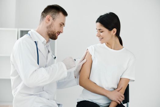 doctor injecting covid-19 vaccine into female patient's shoulder. High quality photo