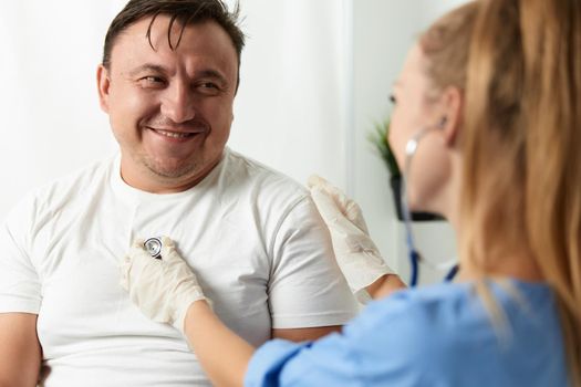 cheerful male patient next to female doctor checkup hospital. High quality photo