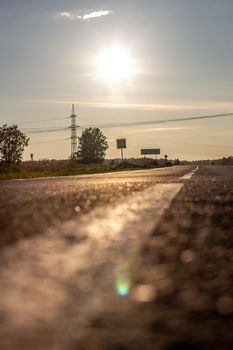 A long white stripe, like a road marker. A road into the distance between fields and forests. High quality photo