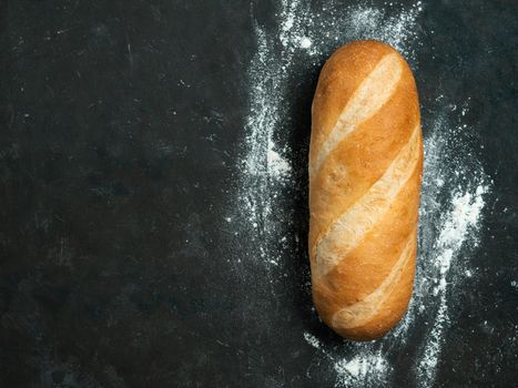 British White Bloomer or European Baton loaf bread on black background. Top view or flat lay. Copy space for text or design