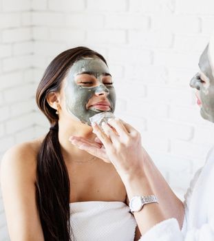 Spa and wellness concept. Self care. Portrait of a beautiful woman applying facial mask doing spa procedures