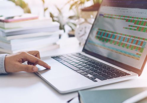 Woman is working on clean nature workspace at home with laptop, planner notebook and calculator. Business finance office concept.