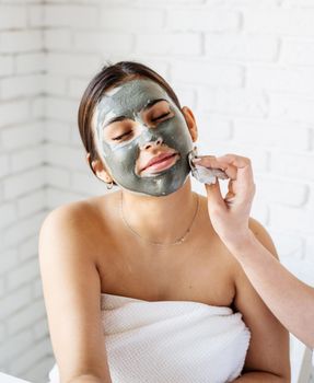 Spa and wellness concept. Self care. Portrait of a beautiful woman applying facial mask doing spa procedures