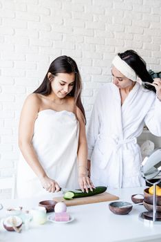 Spa and wellness concept. Self care. two beautiful women doing spa procedures cutting cucumbers