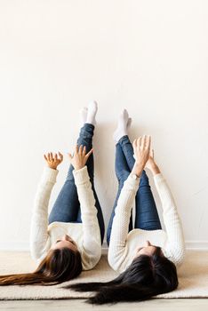 Friendship. Two women laying at the rug legs up having fun