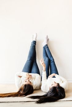 Friendship. Two women laying at the rug legs up having fun