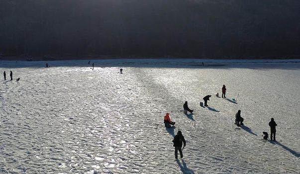 Vladivostok, Russia-December 12, 2018: Aerial view of a frozen Bay with fishermen. People are standing on the surface of white ice.