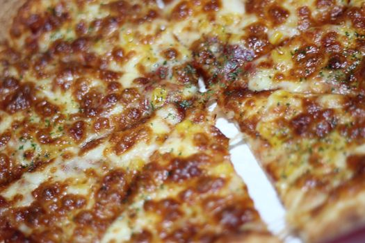 Pizza made with tasty pizza dough, cheese, tomatoes, and green olives. Closeup view of cheese pizza served for dinner