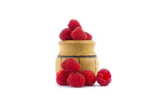 Ripe raspberry fruits and a small wooden pot isolated on white background