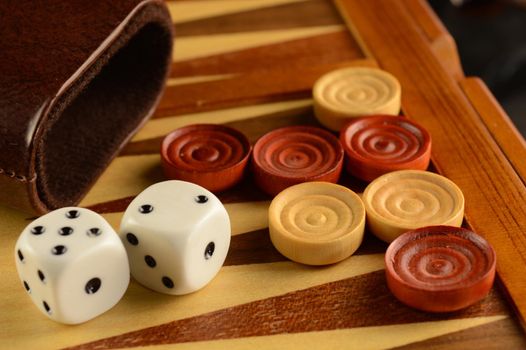A closeup view of a game of Backgammon in play.