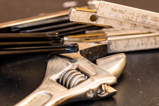 Tools for repair and building. Adjustable spanner, ruler and instruments on black wooden table with copy space