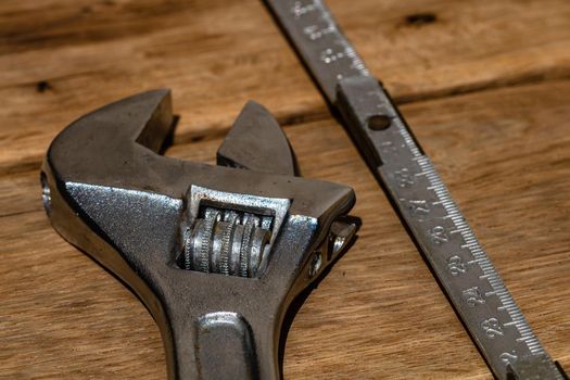 Tools for repair and building. Hummer, adjustable spanner, ruler. Instruments on rustic wooden table with copy space