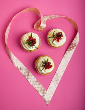 Valentines cupcakes with vanilla icing and decorated with ribbon heart.