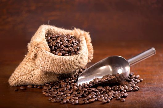 cup of coffee and coffee beans in a sack on dark background