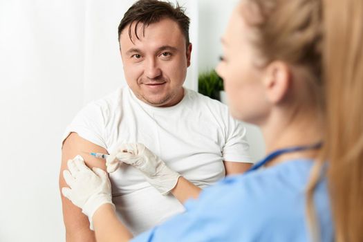 woman doctor injecting man health hospital vaccine. High quality photo