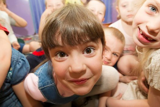 Belarus, the city of Gomil, April 25, 2019.Open day in kindergarten. Funny face of a girl on a background of children. Child in kindergarten