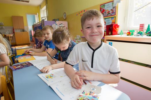 Belarus, the city of Gomel, April 25, 2019. Open day in kindergarten.Children in a drawing lesson in kindergarten. Preschooler with pencil and notebook