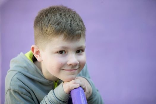 Belarus, the city of Gomil, April 25, 2019. Open day in kindergarten .Six year old boy. Primary school student. Preschooler. Child on a purple background.