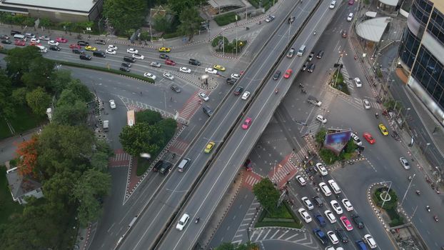 Traffic on crossroad on street. From above modern cars and motorcycles driving on intersection on street in center of Bangkok, Thailand.