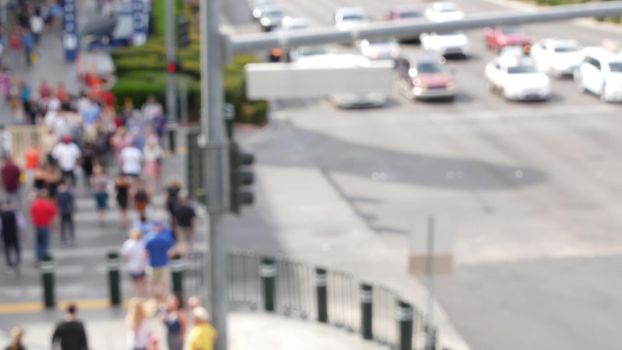 Defocused crowd of people, road intersection crosswalk on The Strip of Las Vegas, USA. Anonymous blurred pedestrians on walkway in crowded urban downtown. Unrecognizable american citizens in sin city.