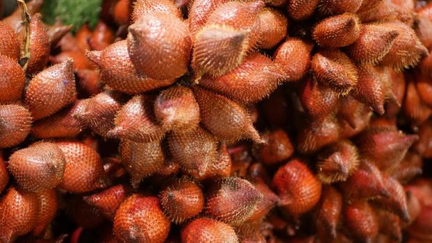 Fruits and vegetables on rustic stall. Assorted fresh ripe fruits and vegetables placed on rustic oriental stall in market. Red Salak. Salacca zalacca species of palm tree also known as snake fruit.